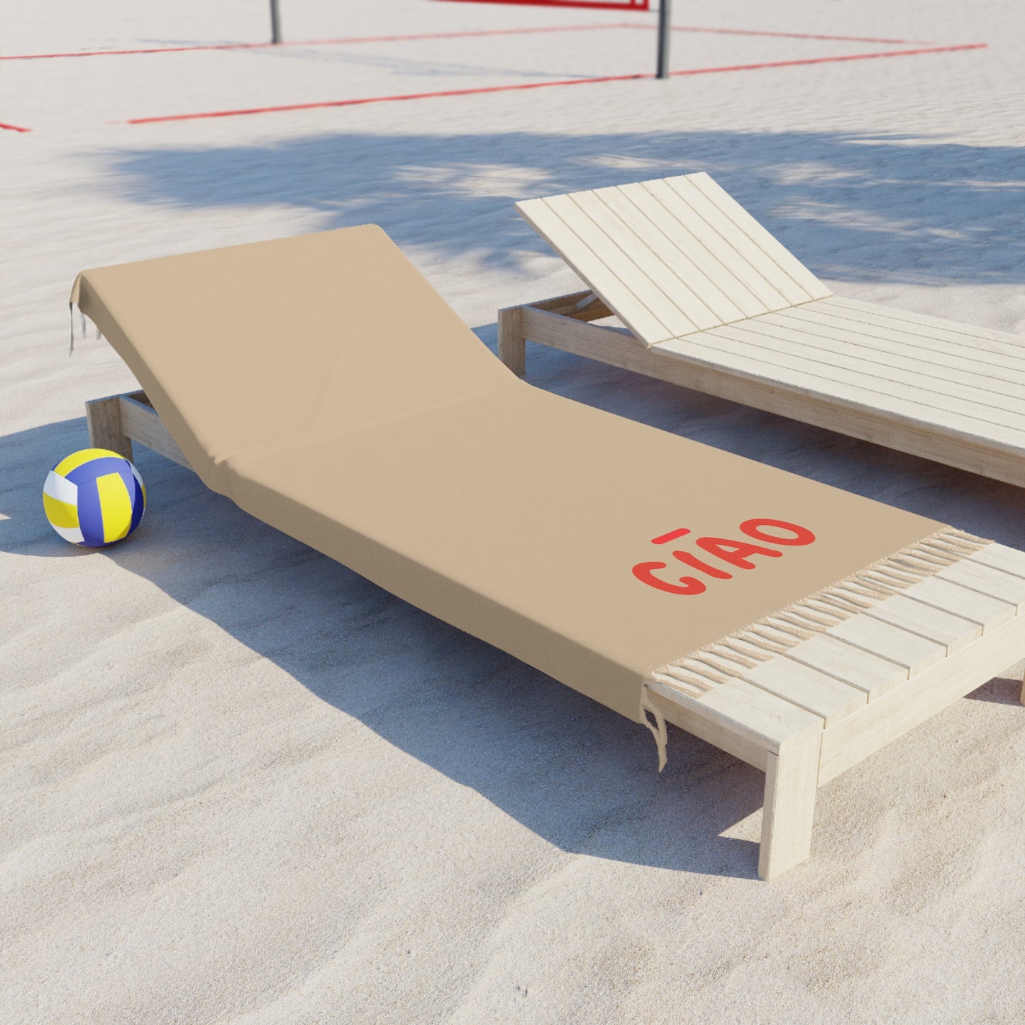 Beige lounge chair with 'Cñao' text on a sandy surface with a volleyball nearby.