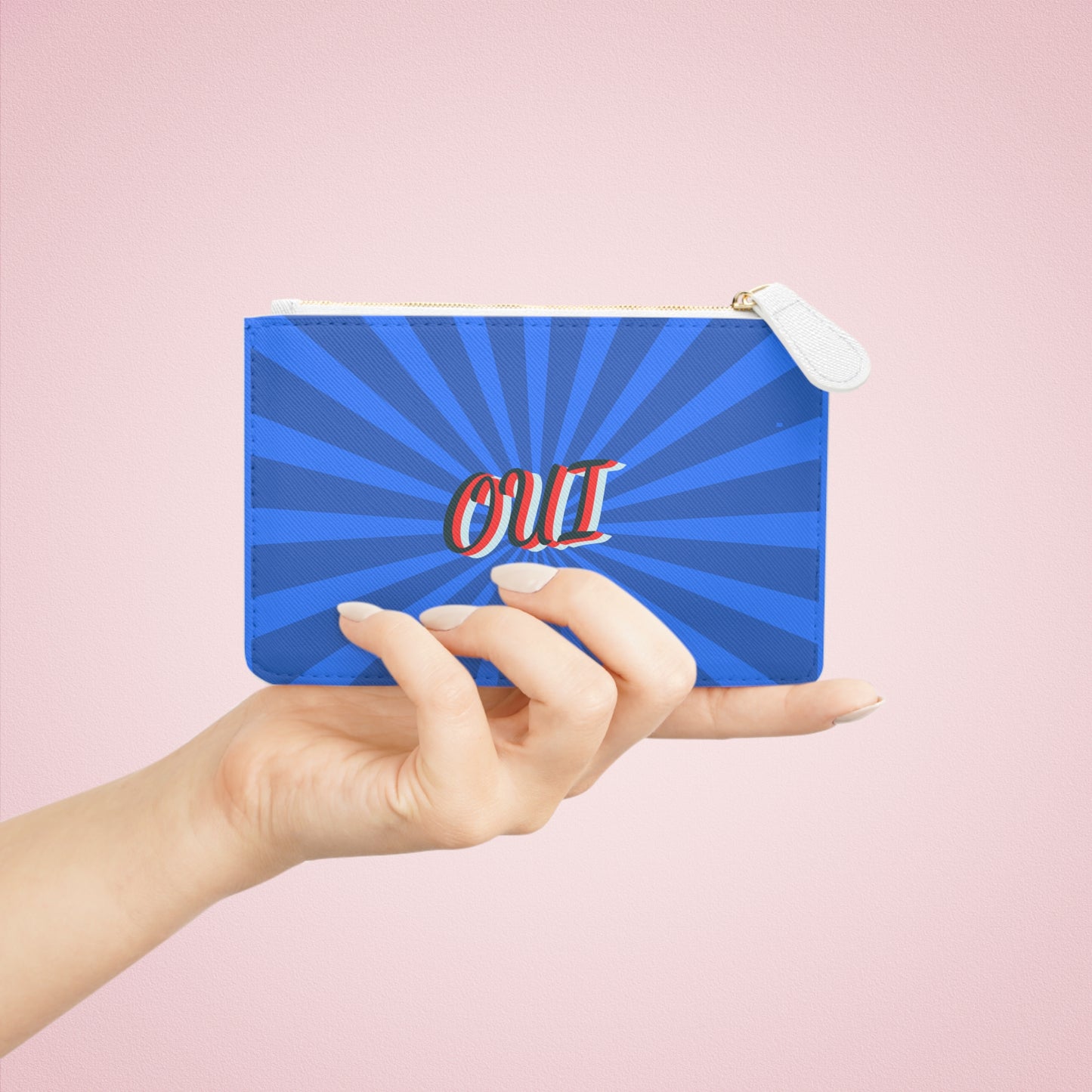 Hand holding a blue pouch with 'OUI' text on a pink background
