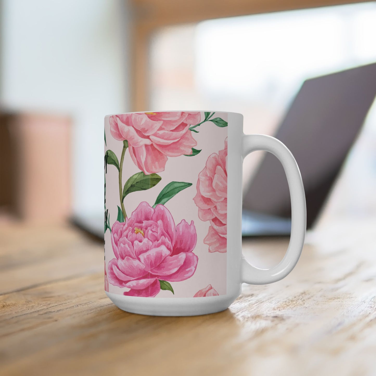 White mug with pink floral design on a wooden surface