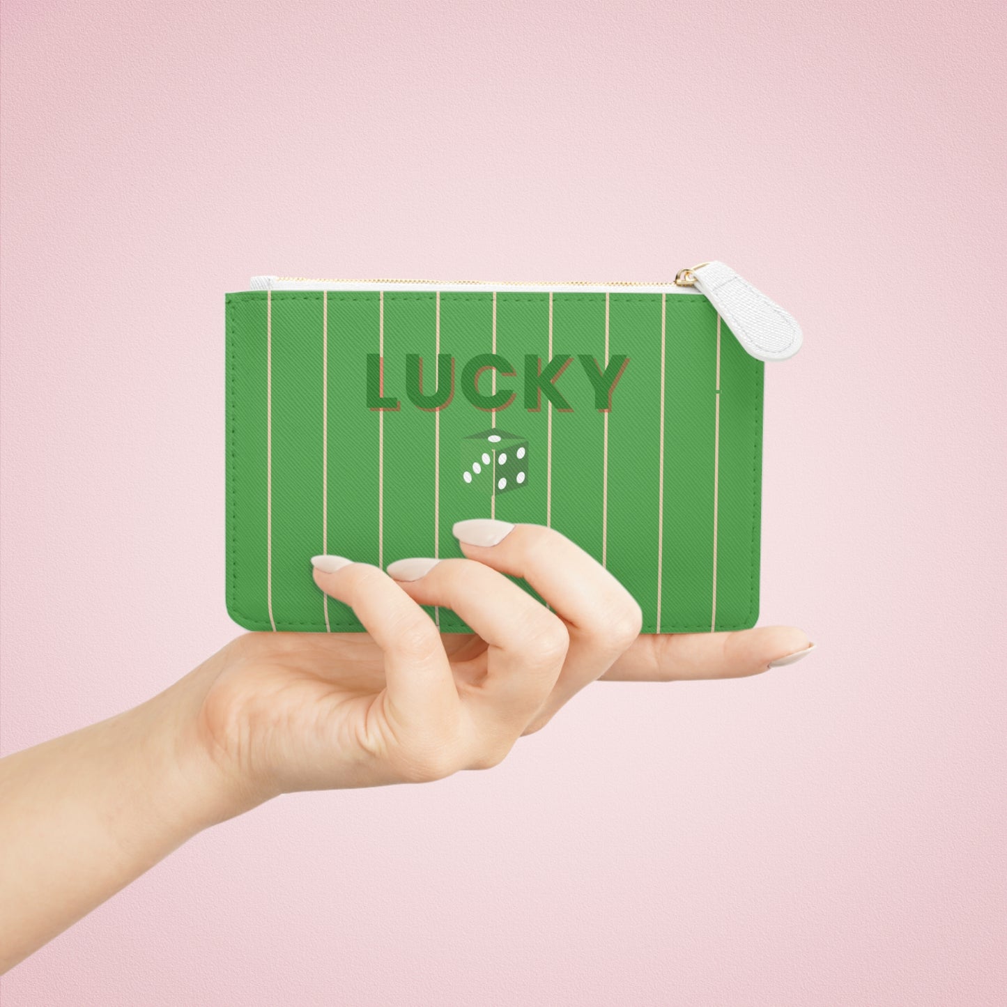 Green pouch with 'LUCKY' text held by a hand against a pink background