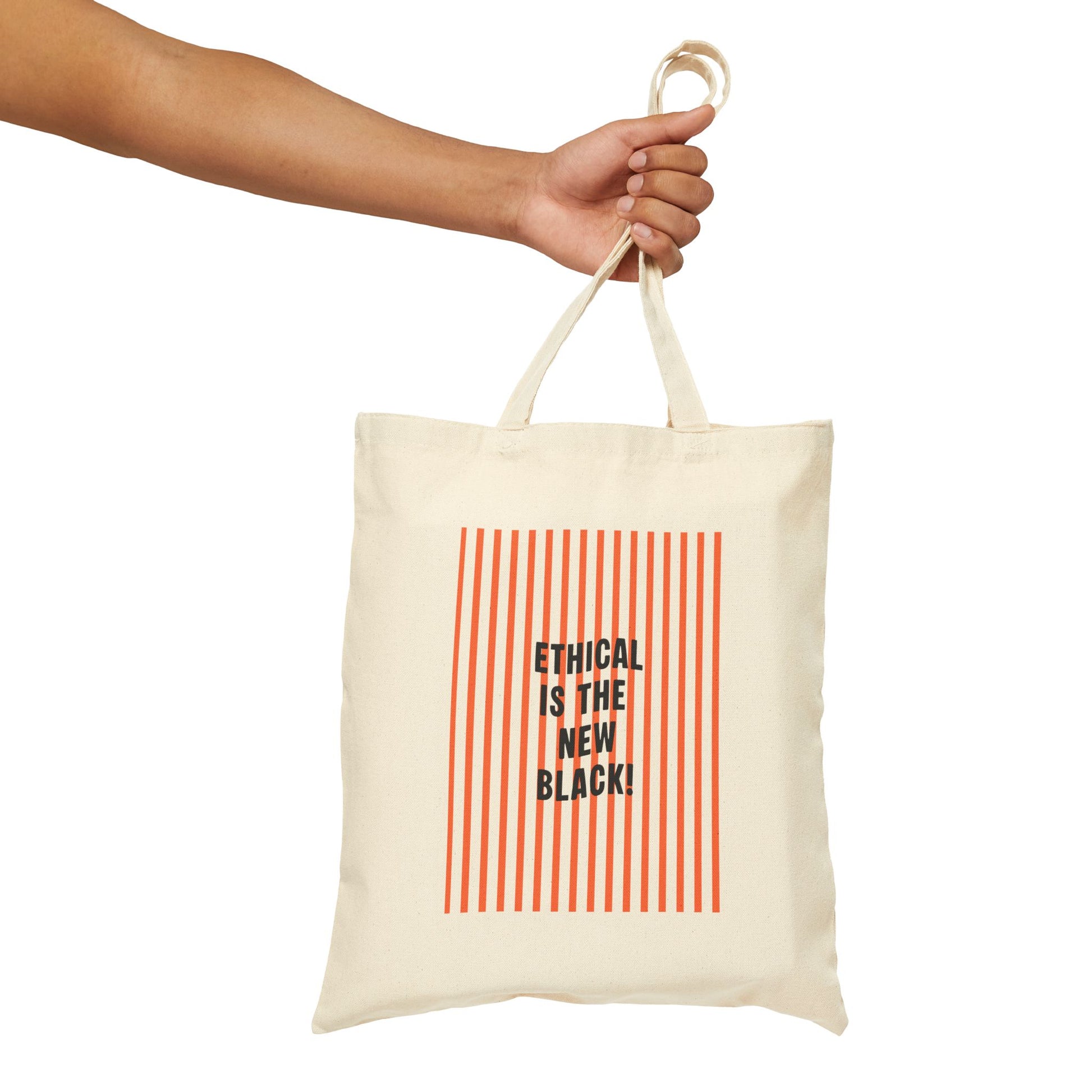 Tote bag with 'Ethical is the New Black' text and red stripes held by a hand on a white background