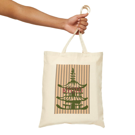 Tote bag with pagoda design and 'Kyoto' text held by a hand on a white background