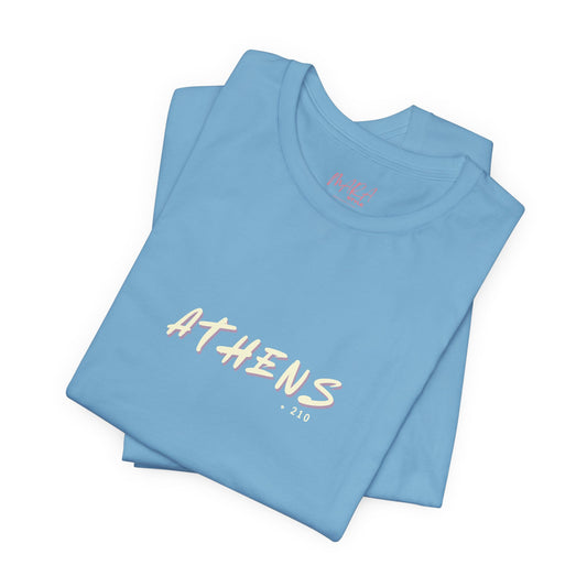 Folded light blue t-shirt with 'ATHENS' text on a white background