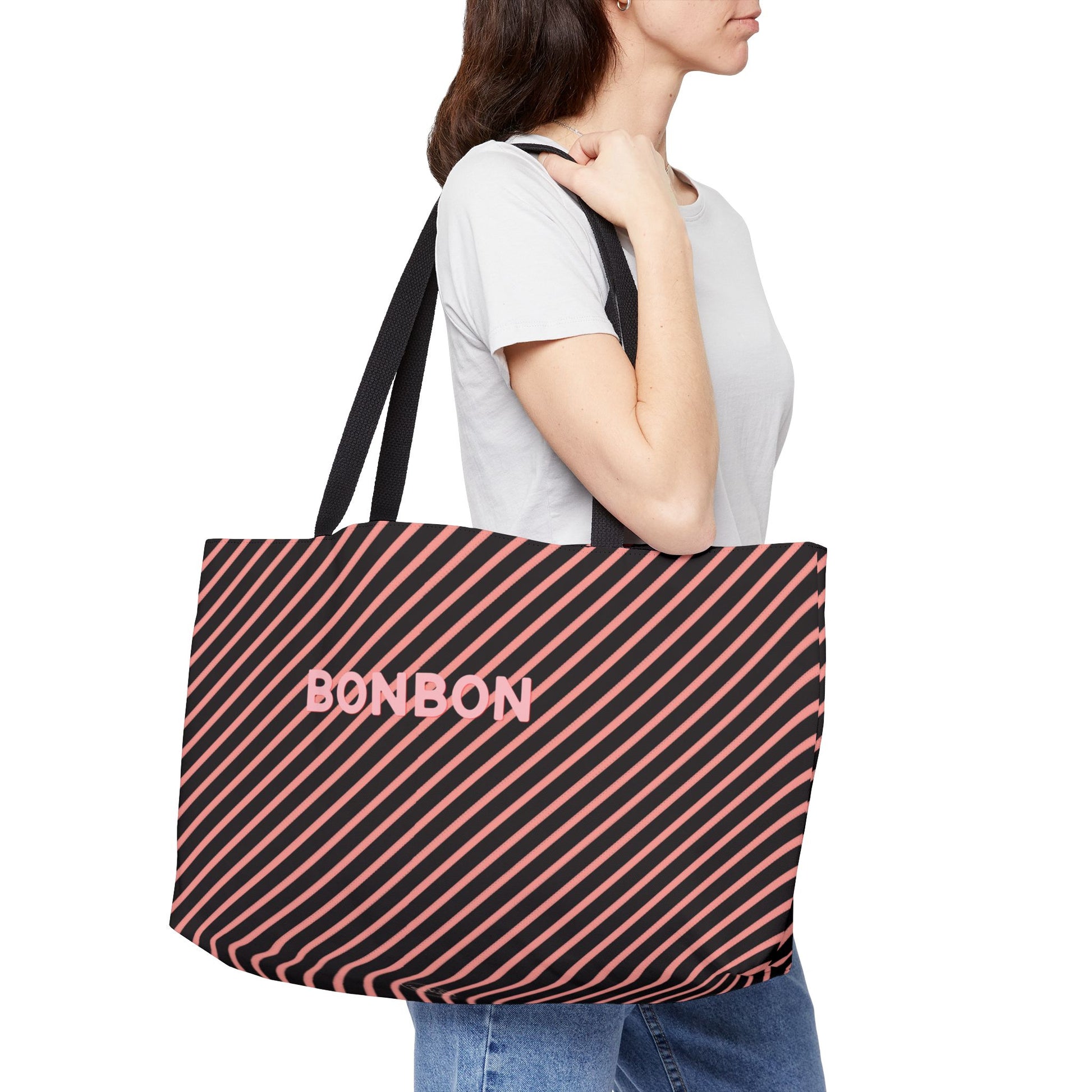 Person carrying a striped tote bag with 'BONBON' branding on a white background
