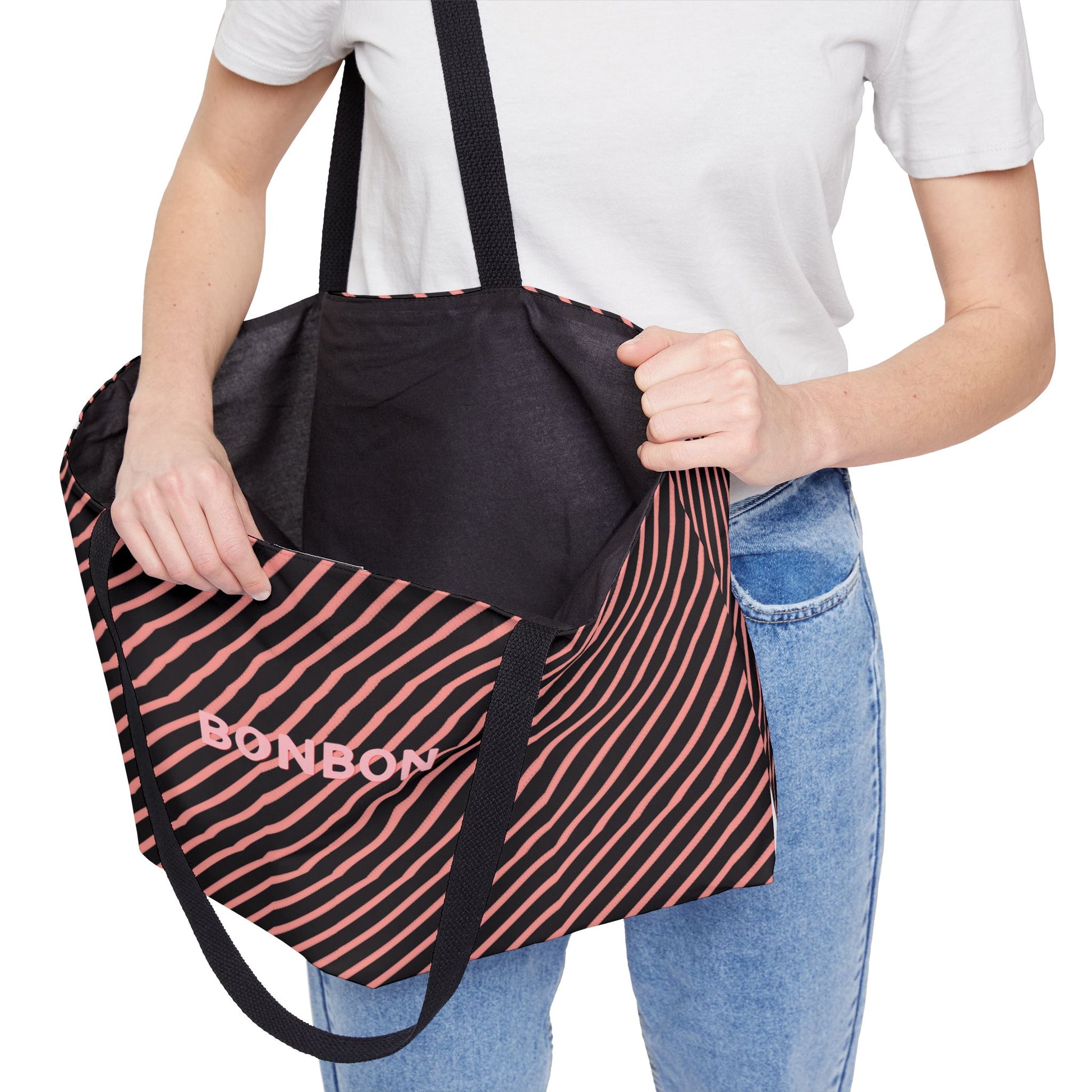 Person holding a black and pink striped bag with 'BONBON' branding.