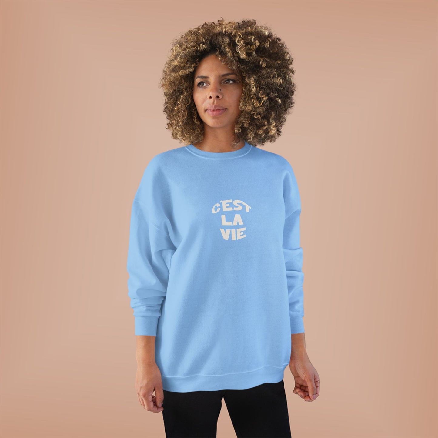 Woman wearing a light blue sweatshirt with text on a beige background