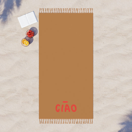 Brown towel with 'GIAO' branding on a textured surface with a book and fruit.