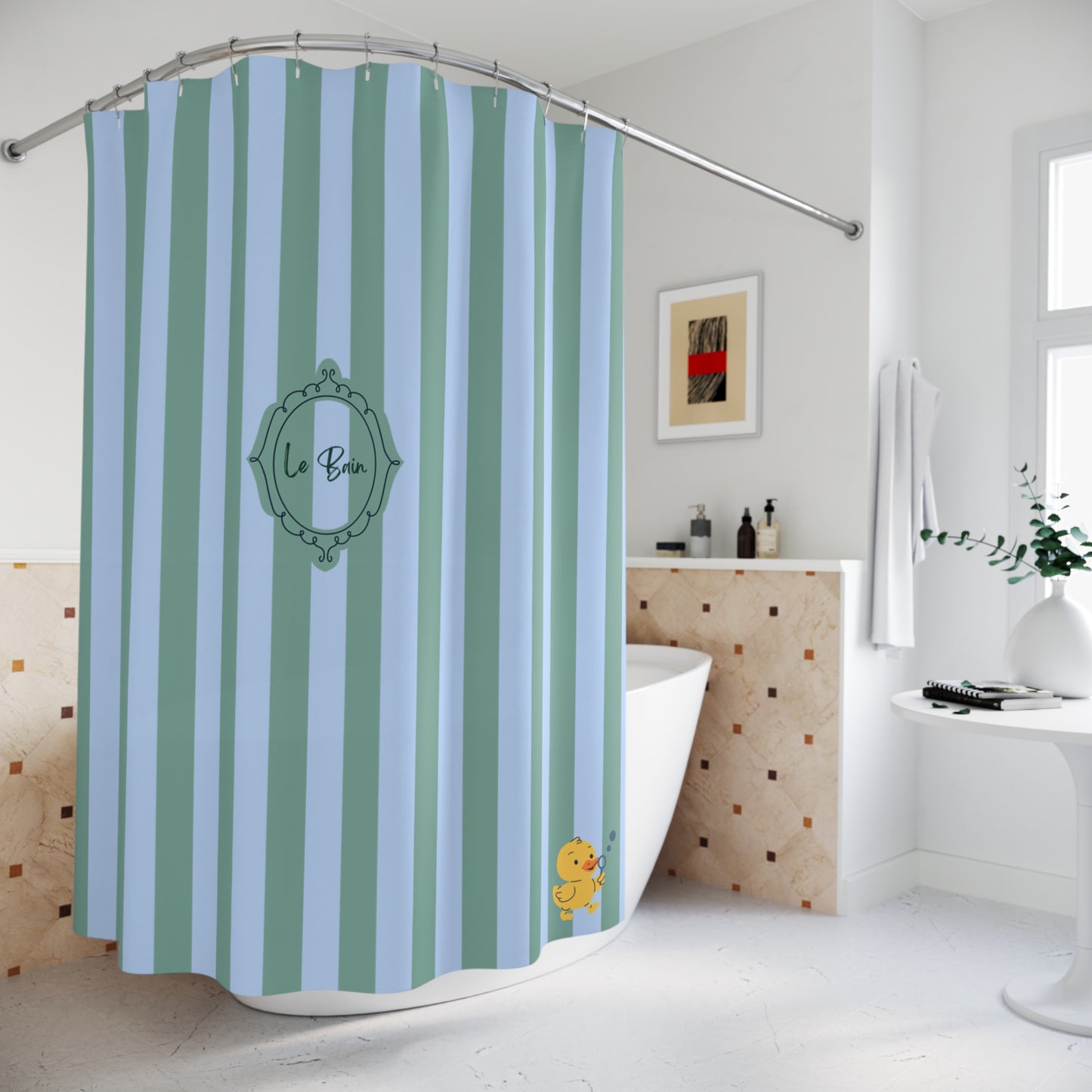 A personalized shower curtain with vertical light blue and mint green stripes, featuring a central green ornate frame with the name 'La Bea' in script and a small yellow duck character near the bottom. The curtain is shown hanging in a bright, modern white bathroom.
