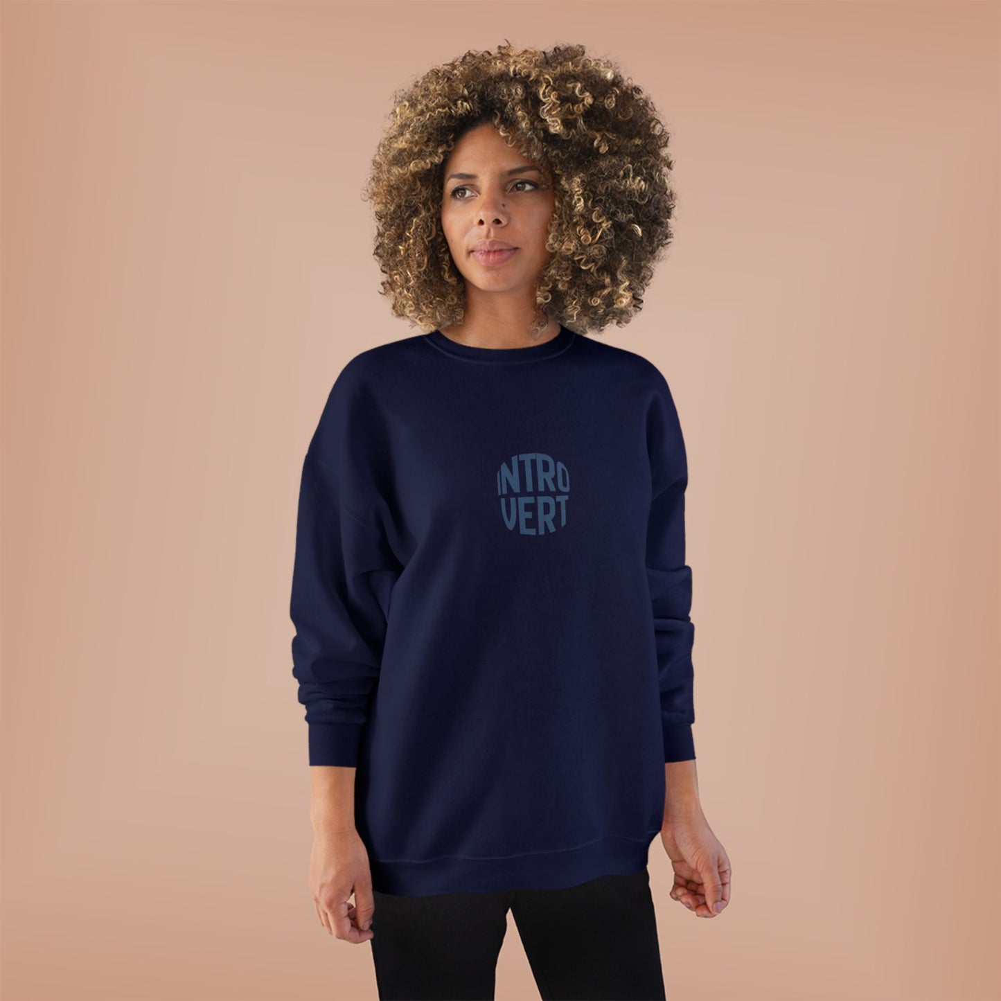 Person wearing a navy sweatshirt with 'INTROVERT' text on a beige background