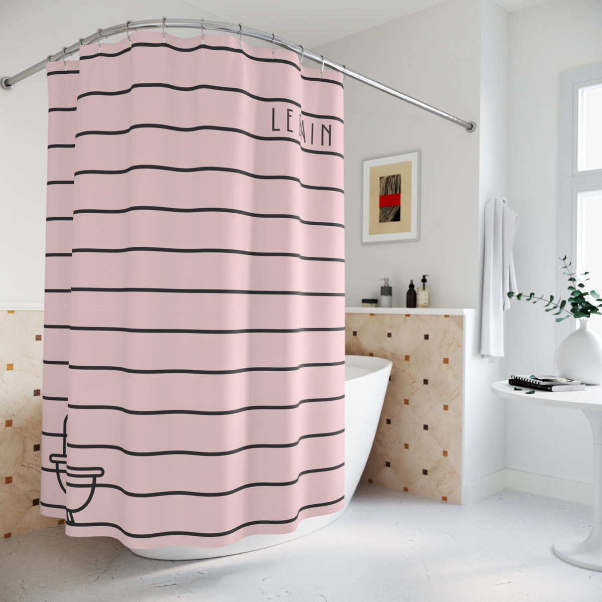 A pink shower curtain with horizontal black stripes and the word 'LEVIN' printed near the top right, hanging in a bright white bathroom next to a bathtub.