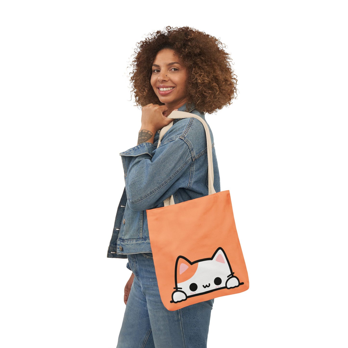 Woman holding an orange tote bag with a cat design on a white background