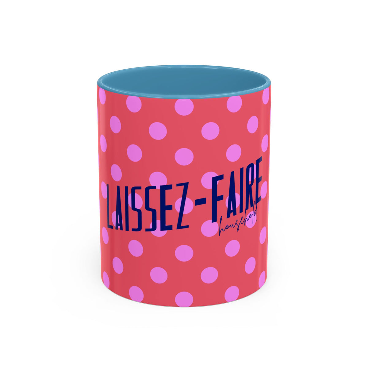 A ceramic mug with a coral pink exterior patterned with light pink polka dots, featuring the text 'LAISSEZ-FAIRE housing' in navy blue. The interior of the mug is a contrasting light blue, shown against a plain white background.