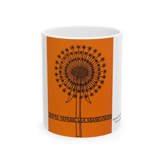 White mug with an orange design featuring a black dandelion-like pattern on a white background