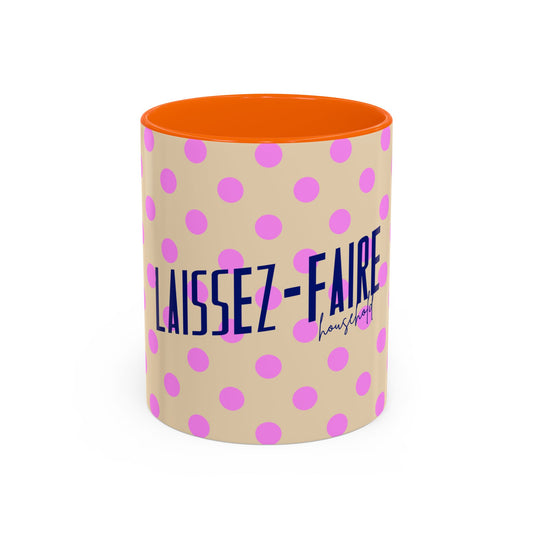 A cylindrical mug with a beige exterior covered in pink polka dots, featuring the French text 'LAISSEZ-FAIRE' in dark blue and a small 'household' signature below. The interior of the mug is bright orange, shown against a plain white background.
