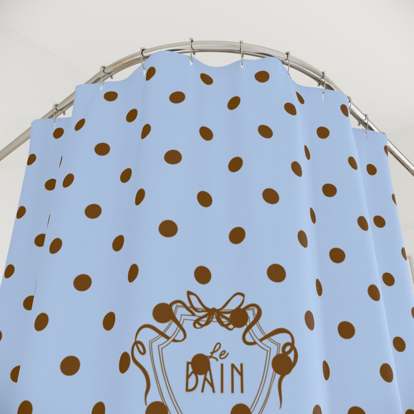 Blue dress with brown polka dots and 'Le Bain' logo on a hanger