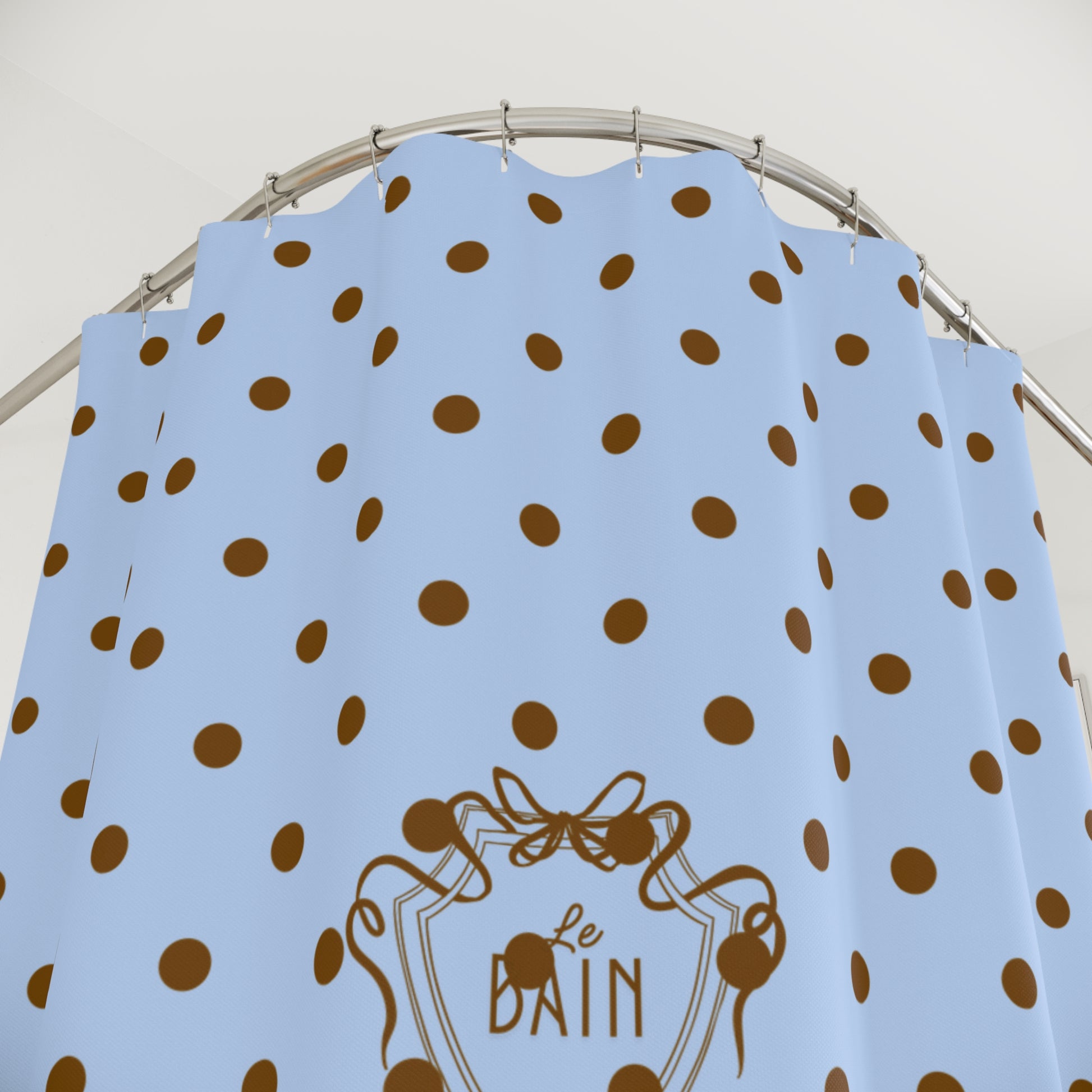Blue dress with brown polka dots and 'Le Bain' logo on a hanger