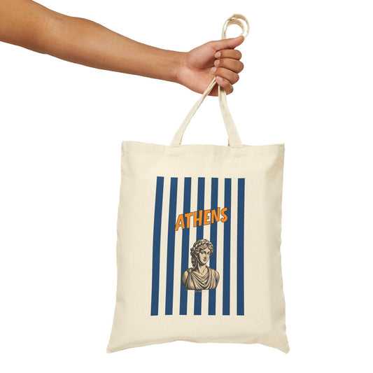 Tote bag with 'Athens' design held by a hand on a white background