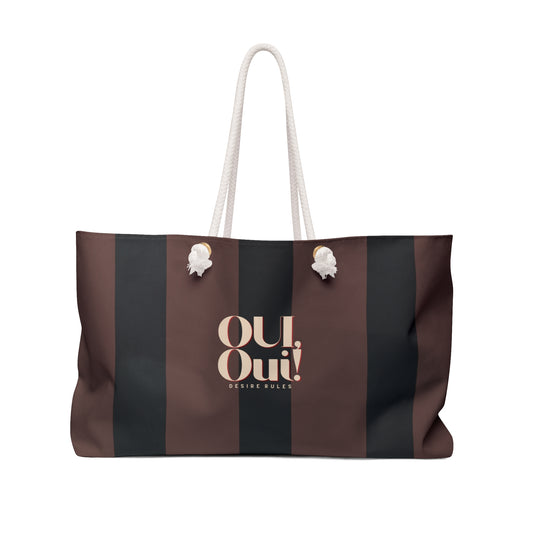 A striped tote bag with vertical brown and black stripes, featuring a cream-colored rope handle and a cream logo on the front that reads 'Oui Oui! DESIGN OUVERT'.