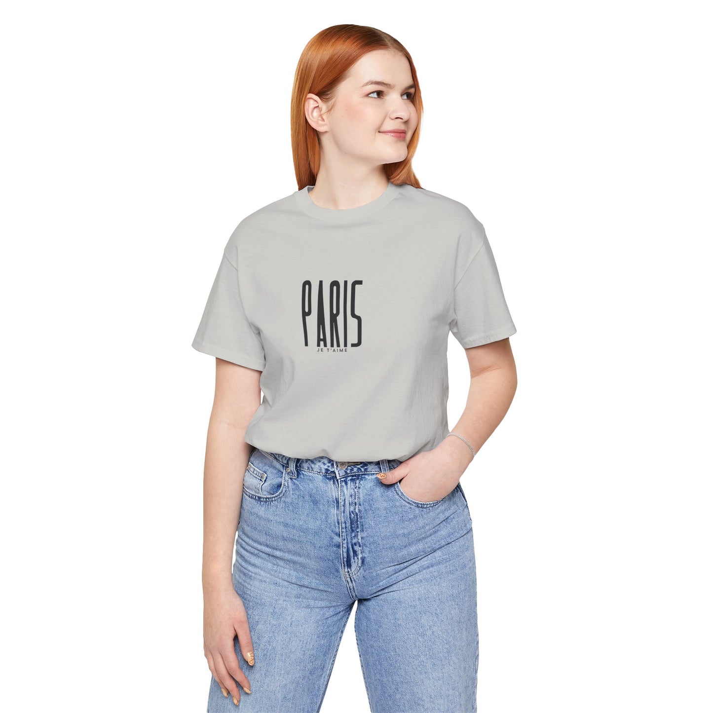 Person wearing a gray t-shirt with 'PARIS' text and blue jeans on a white background