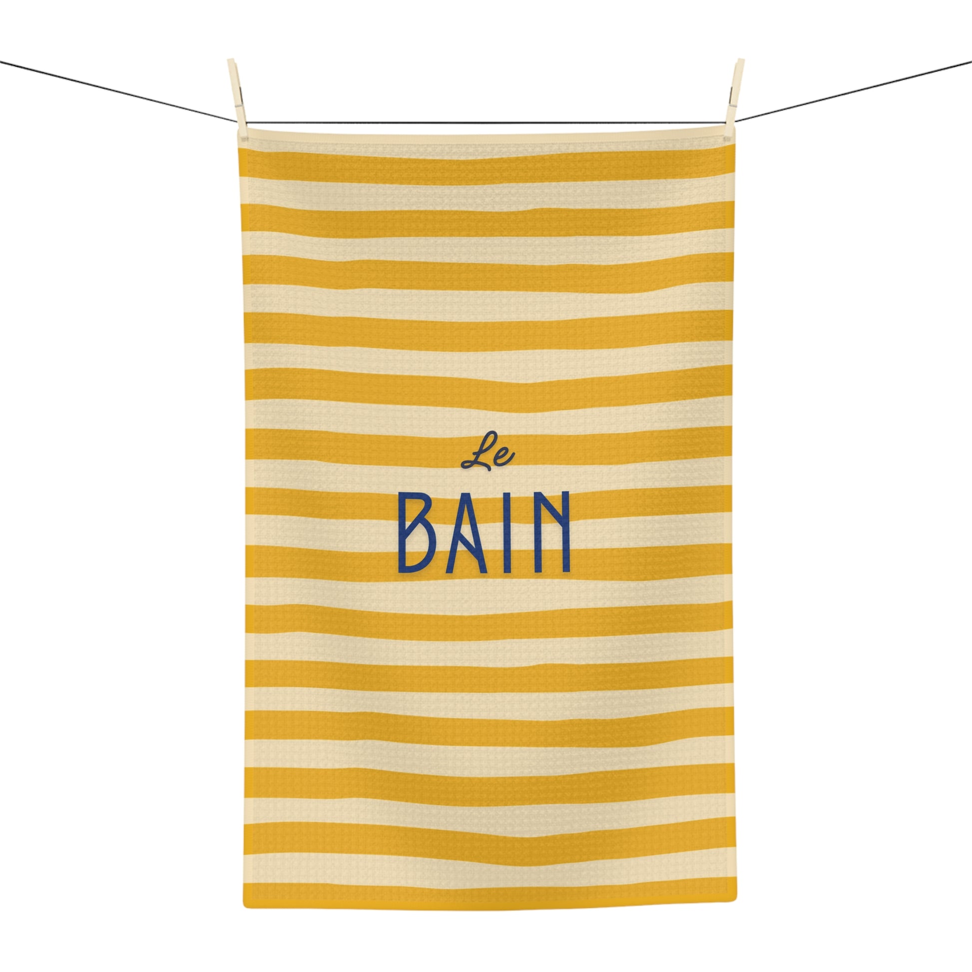 Striped towel with 'Le Bain' text hanging on a line