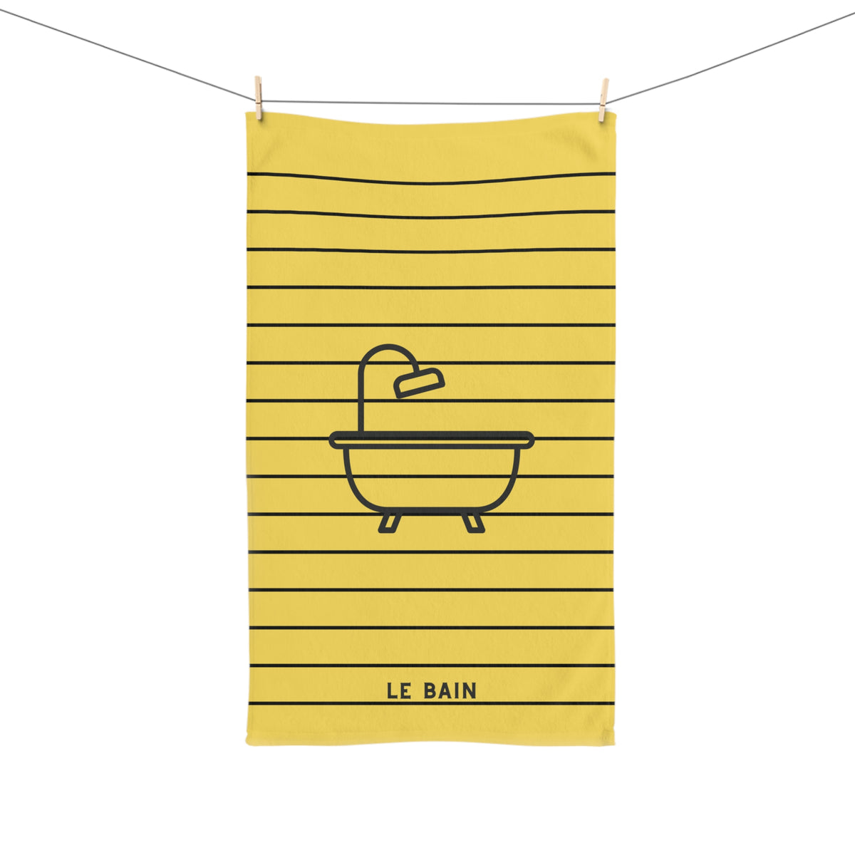 A yellow kitchen towel with black horizontal stripes and a black line-art illustration of a bathtub with a faucet. The words 'LE BAIN' are printed at the bottom.