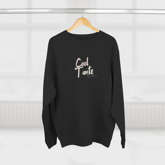 Black sweater with 'Cool Tante' text on a wooden hanger against a white background