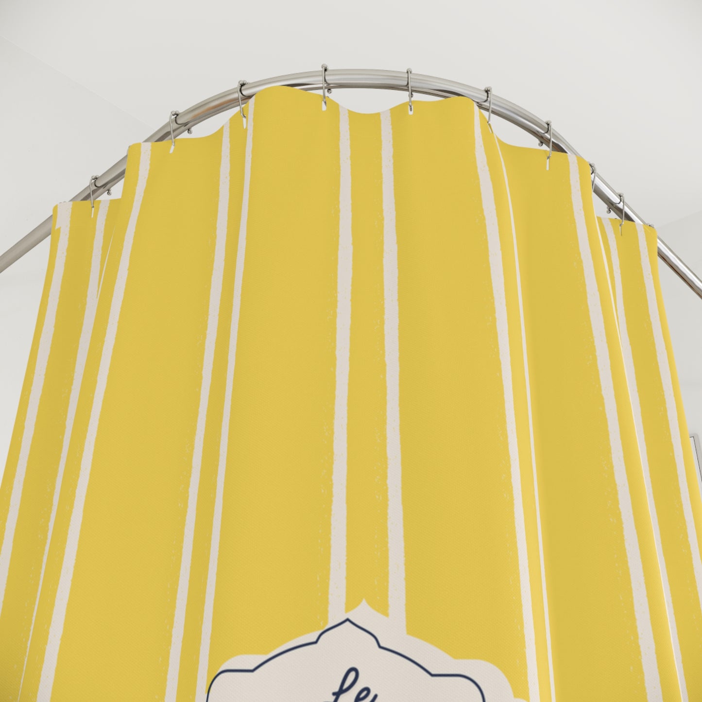 Yellow shower curtain with white vertical stripes on a metal rod against a white background