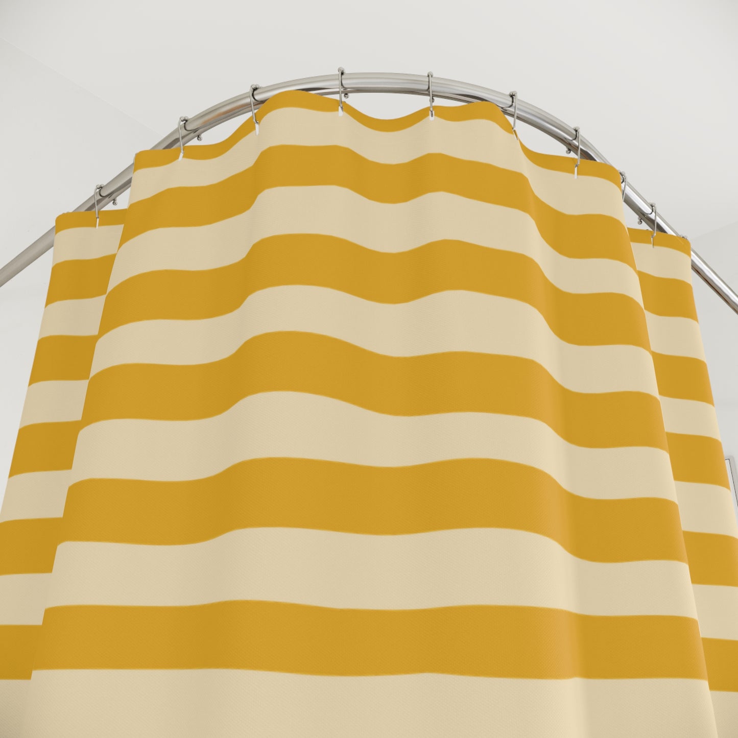 Yellow and beige striped shower curtain on a silver rod against a white background