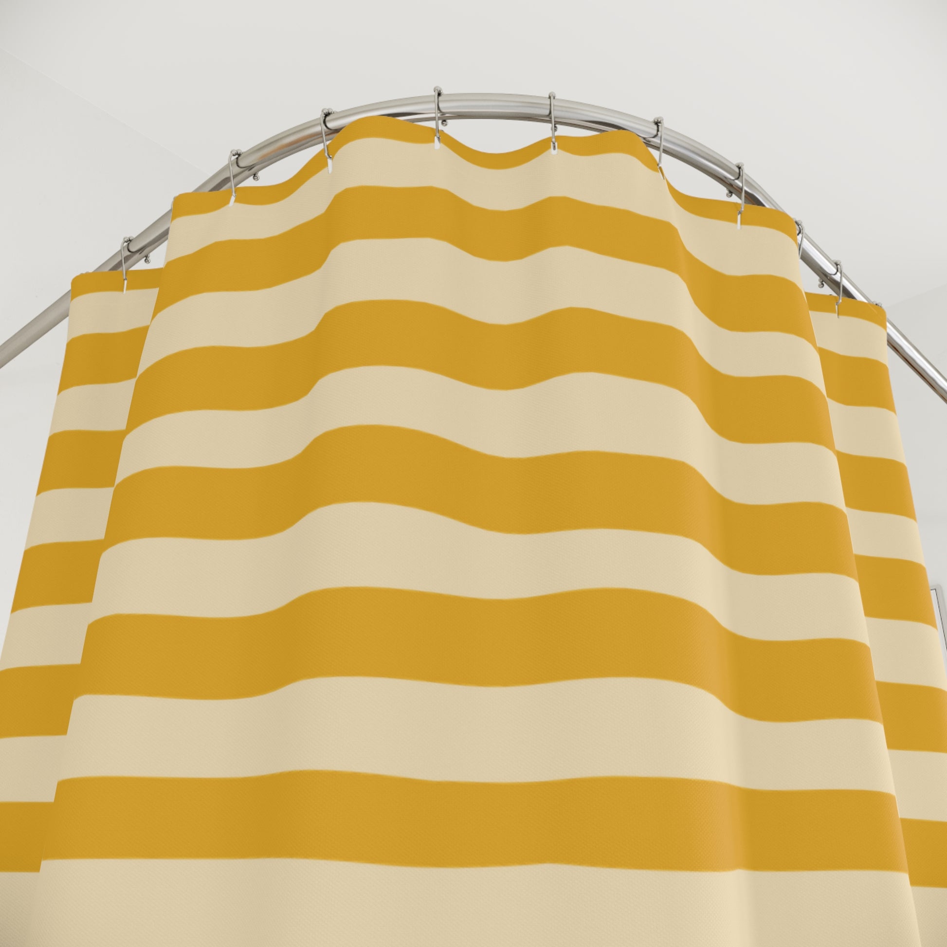 Yellow and beige striped shower curtain on a silver rod against a white background