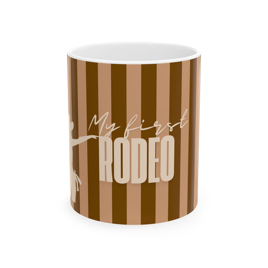 A ceramic mug with a brown and tan striped pattern, featuring the text 'My first RODEO' in white and beige, on a solid white background.