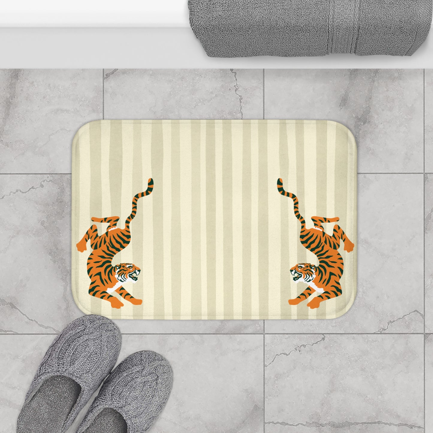 Bath mat with tiger design on a striped background, placed on a tiled floor.