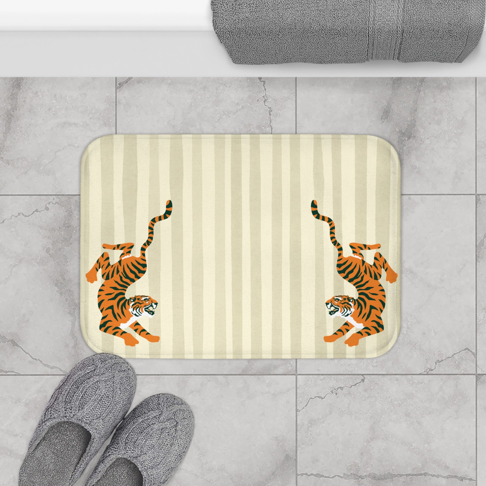 Bath mat with tiger design on a striped background, placed on a tiled floor.