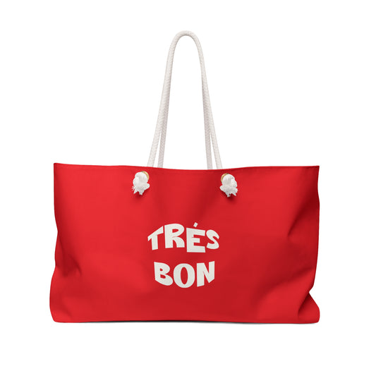 Red tote bag with 'TRéS BON' text on a white background