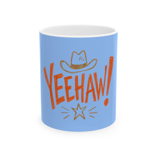 A light blue ceramic mug with a white interior, featuring a hand-drawn style graphic of a cowboy hat above the word 'YEEHAW!' in orange-red lettering, with a small gold starburst below.