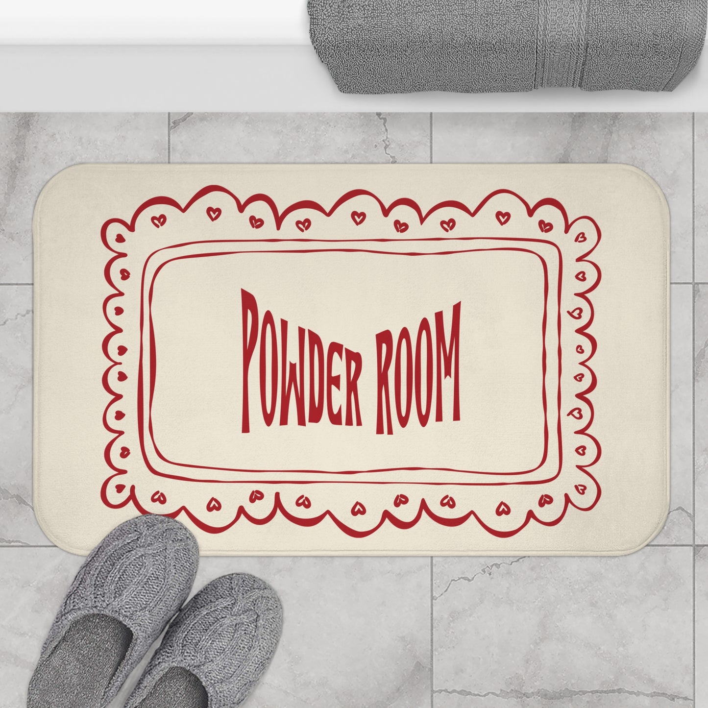 Beige bath mat with red 'Powder Room' text on a marble floor.