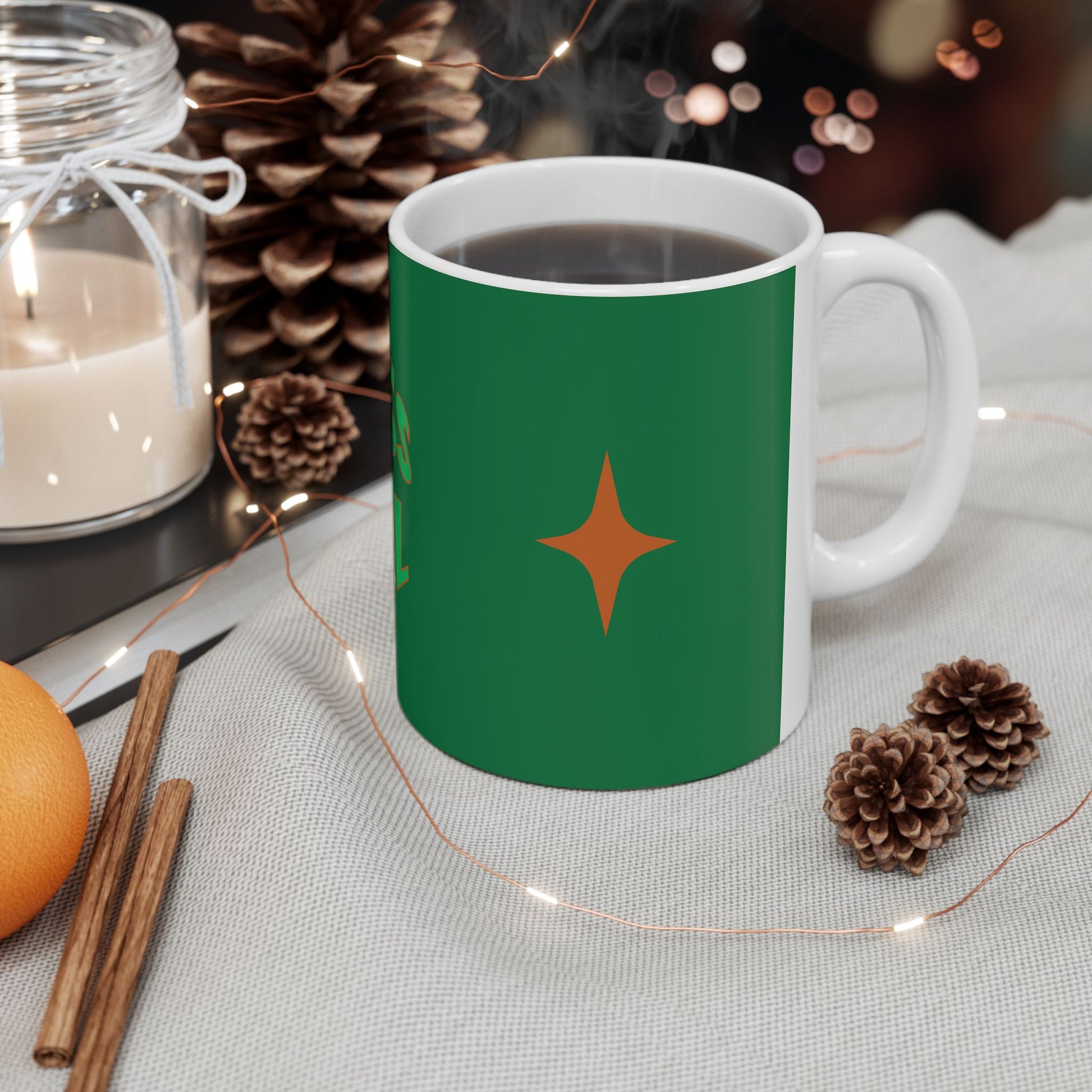 Green mug with a star design on a table with decorative items
