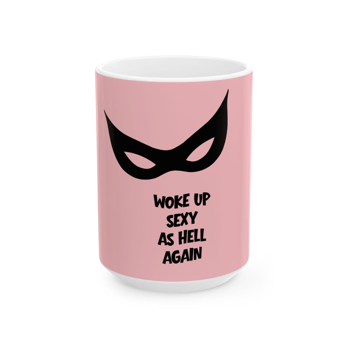 A pink ceramic mug with a white interior and base, featuring a black stylized mask graphic and the text 'WOKE UP SEXY AS HELL AGAIN' in black lettering, shown on a clean white background.