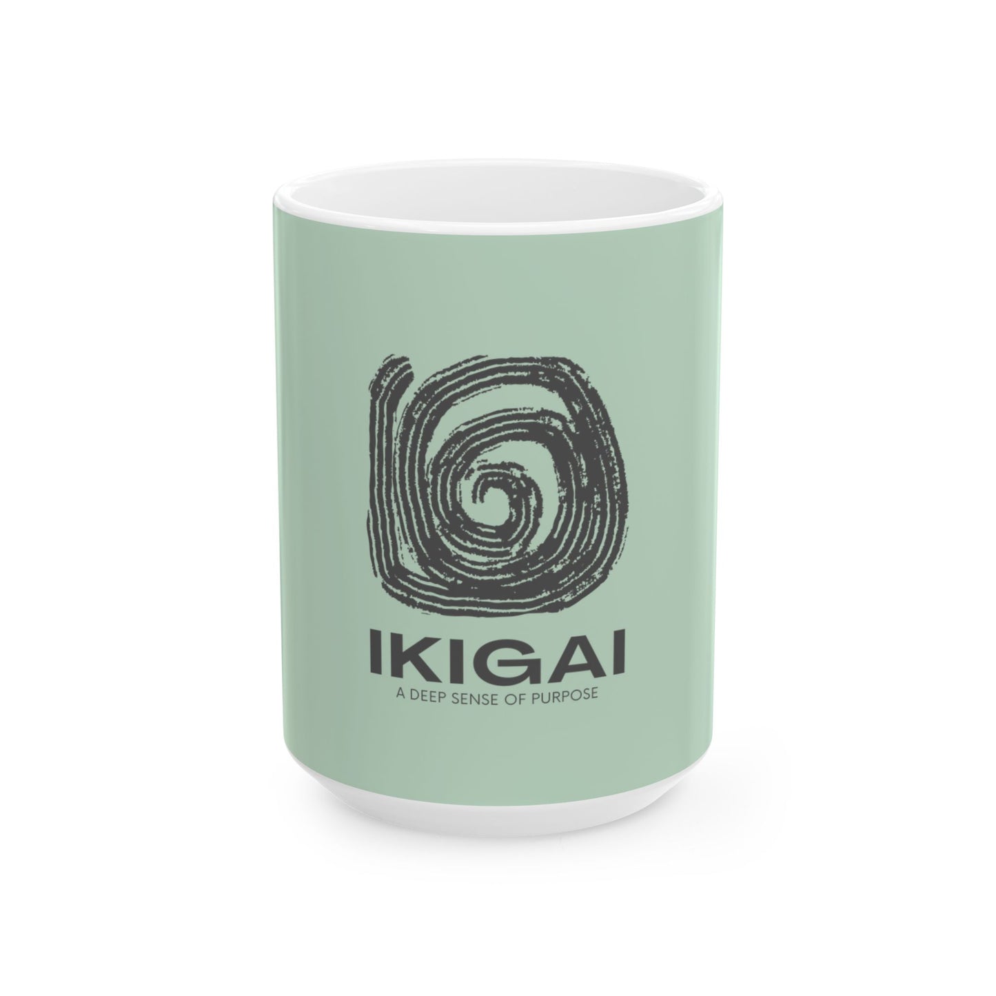 A mint green ceramic mug with a white interior and base, featuring a black spiral graphic and the text 'IKIGAI' and 'A DEEP SENSE OF PURPOSE' on the front, set against a plain white background.