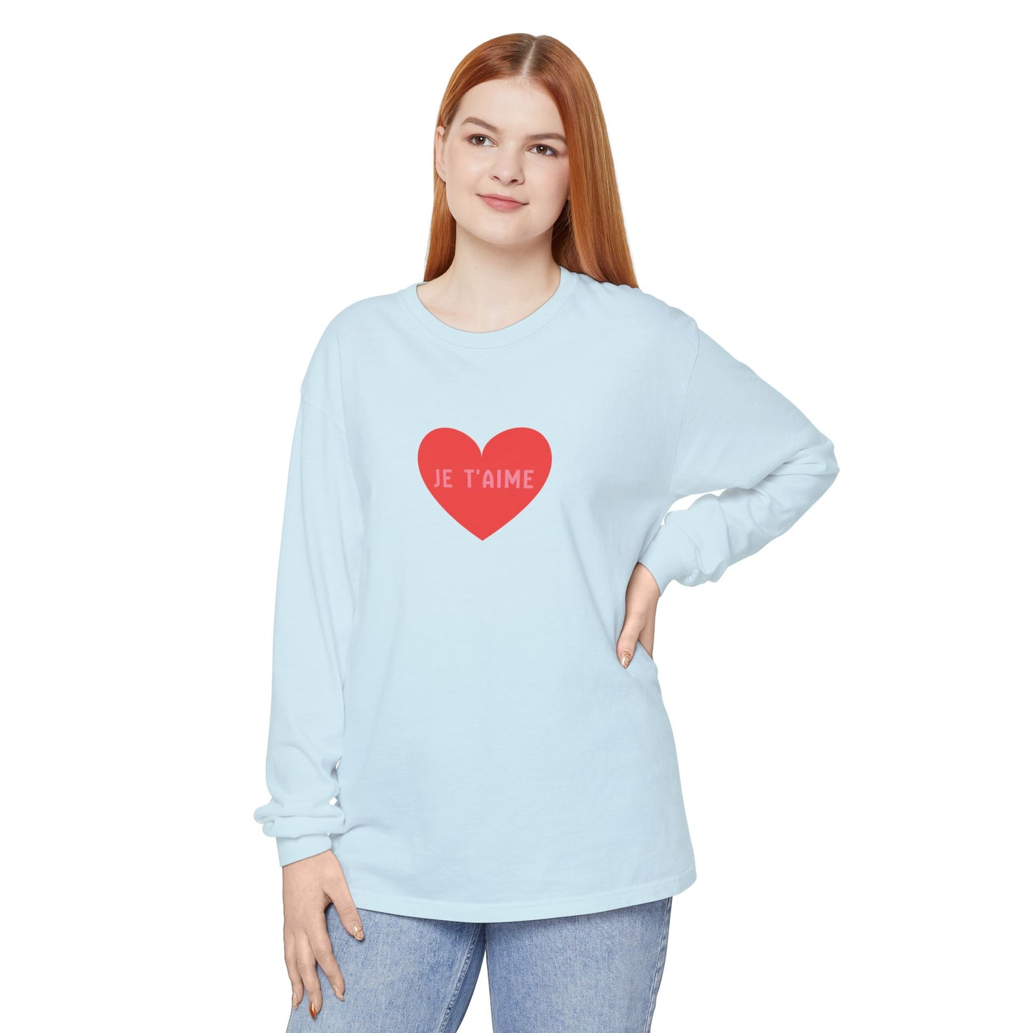 Woman wearing a light blue long-sleeve shirt with a red heart and 'Je T'aime' text on a white background