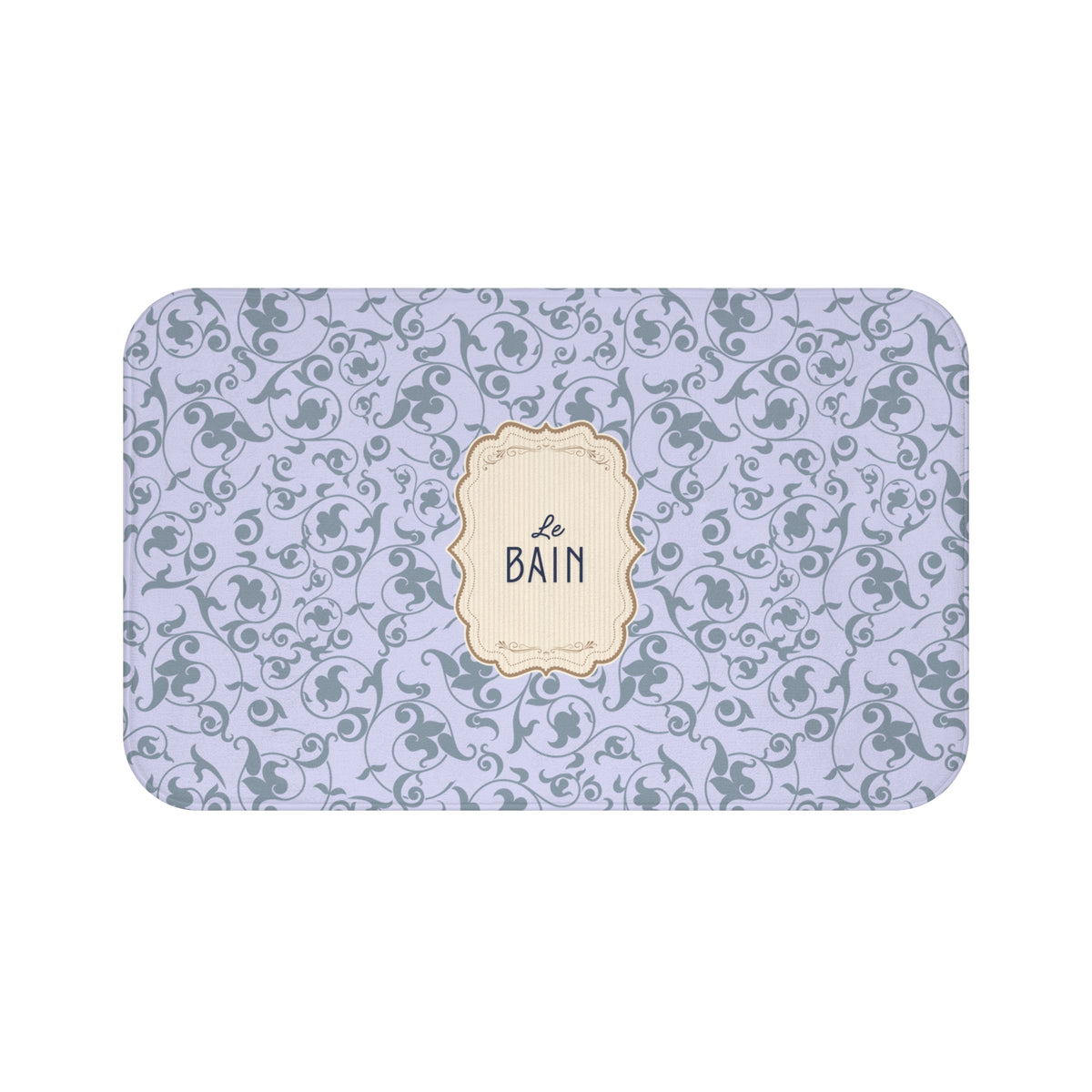 A rectangular bath mat with rounded corners, featuring a light lavender background with a repeating dark gray floral scroll pattern and a central cream-colored decorative label that reads 'Le Bain'.