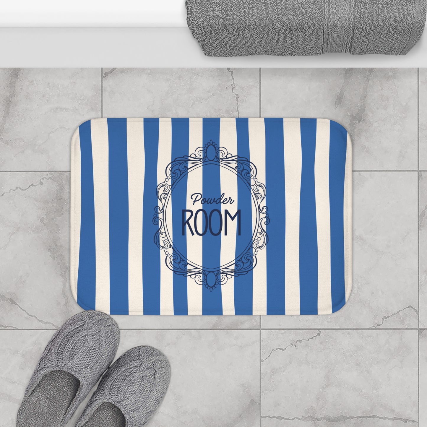 Striped bath mat with 'Powder Room' text on a tiled floor.