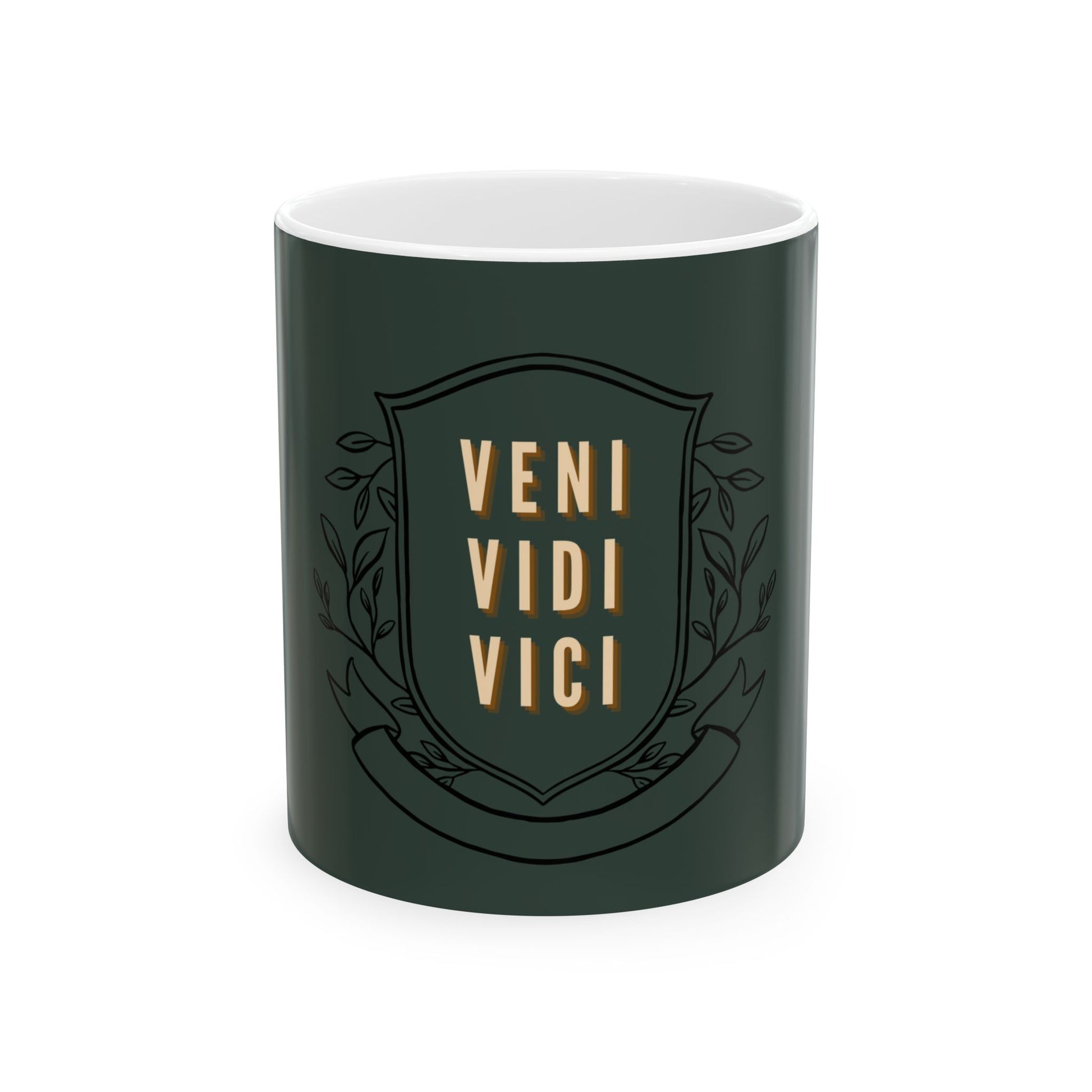 A dark green ceramic mug with a white interior, featuring a black shield emblem with the words 'VENI VIDI VICI' in gold lettering and decorative leaf motifs.