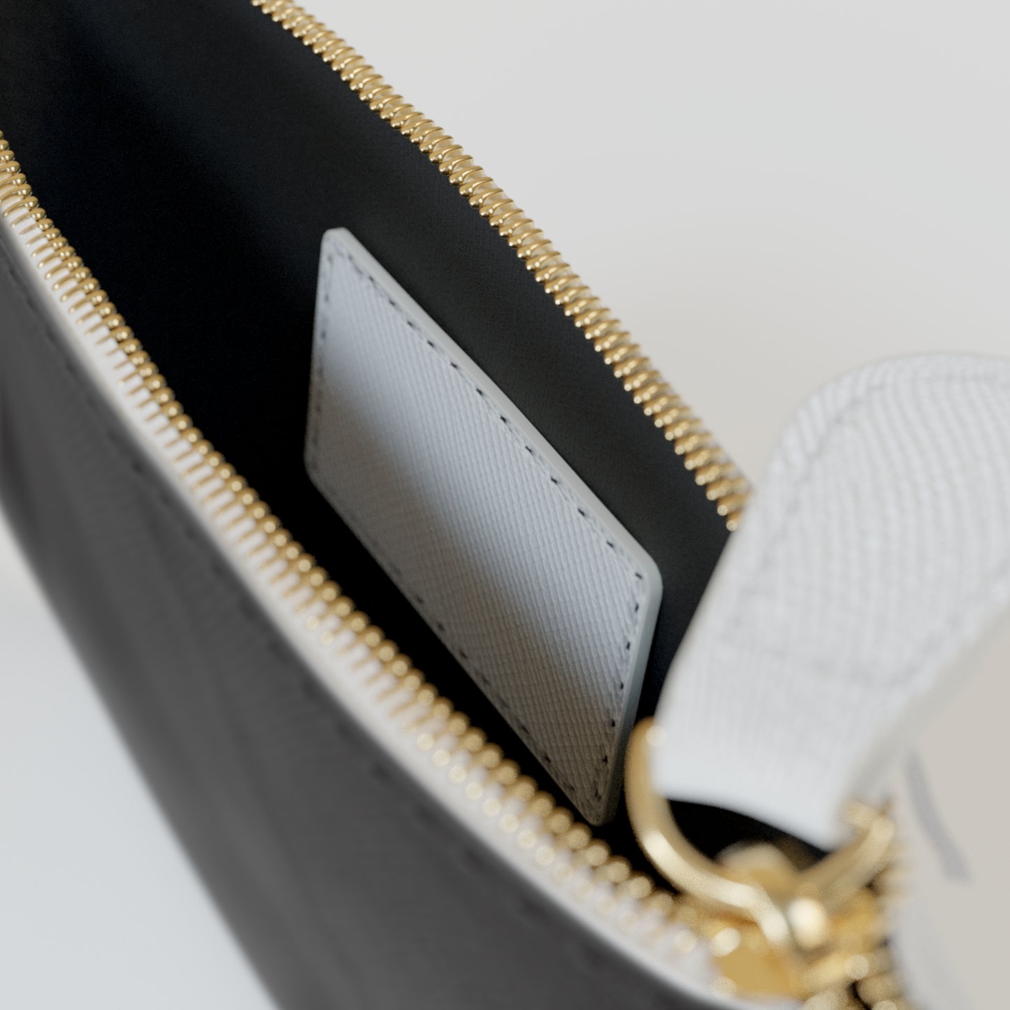 Close-up of a black handbag with gold zipper and white interior.
