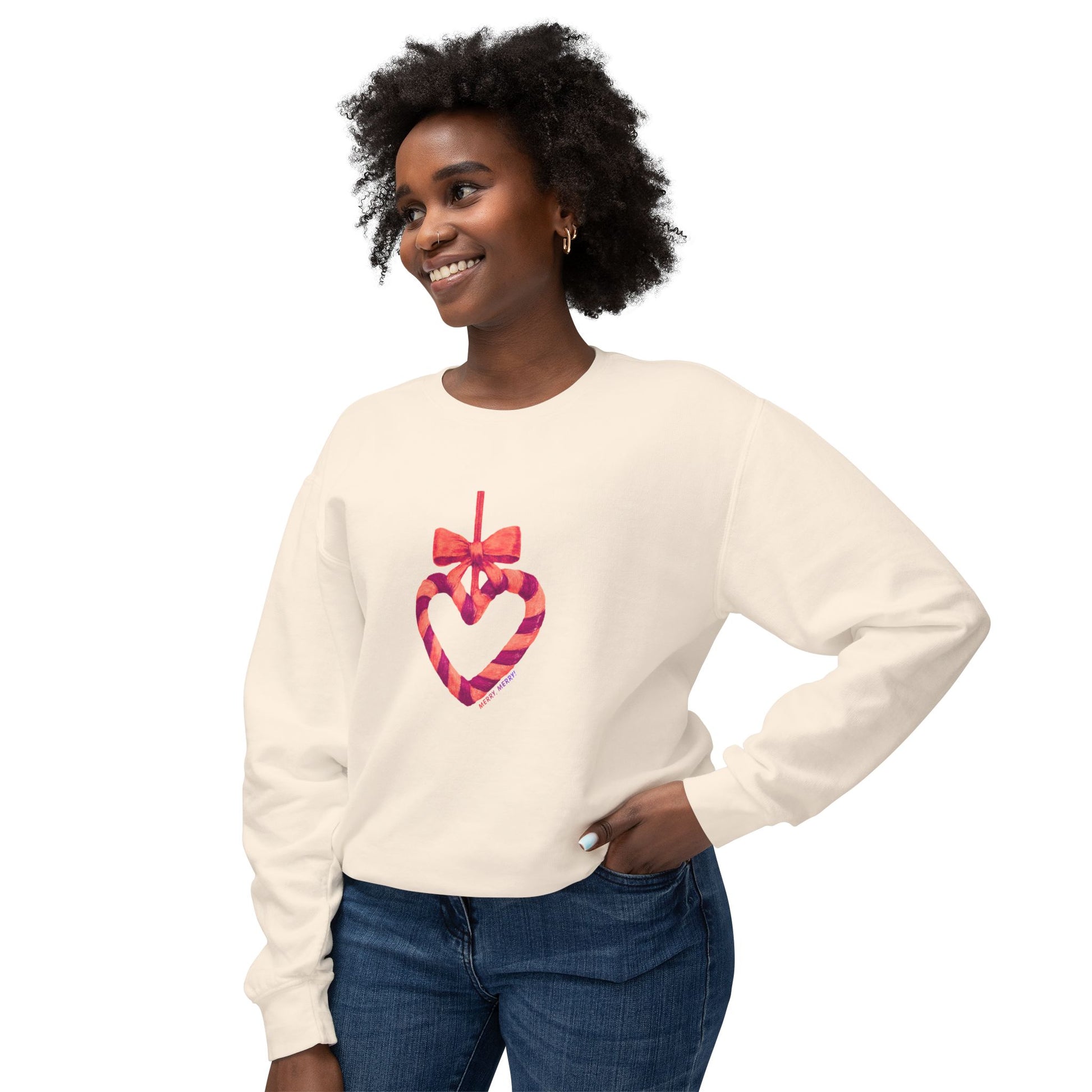 Woman wearing a cream sweater with a colorful heart design on a white background