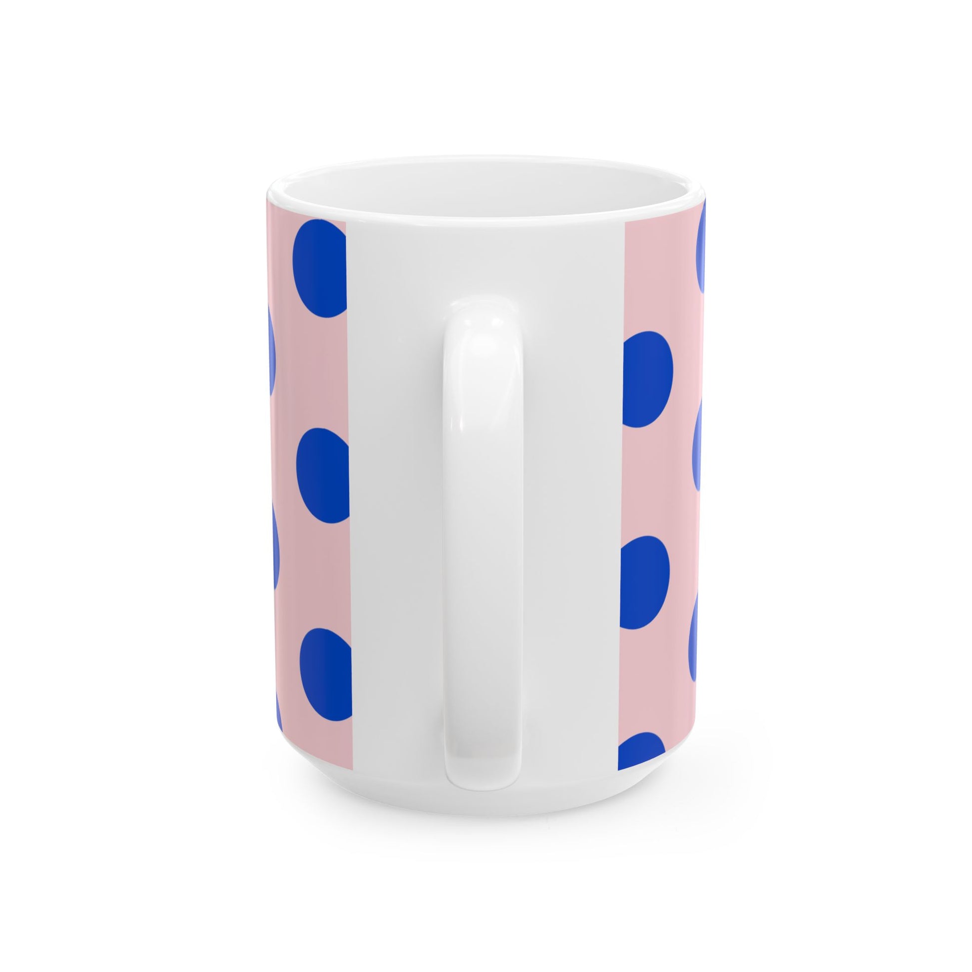 White mug with blue polka dots on a pink background