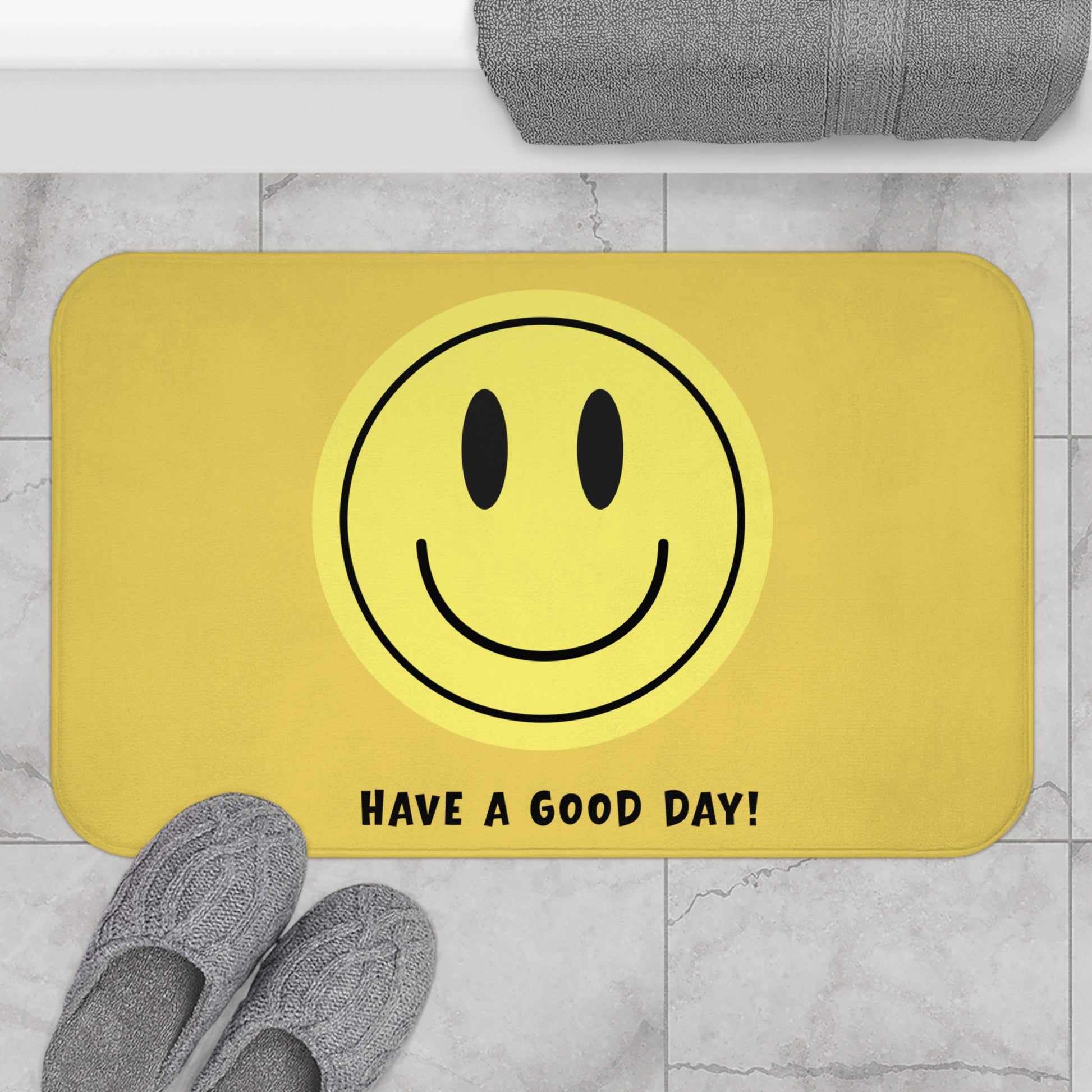 Yellow doormat with smiley face and 'Have a Good Day!' text on a marble floor.