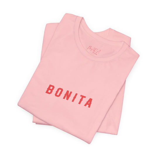 Folded pink t-shirt with 'BONITA' text on a white background