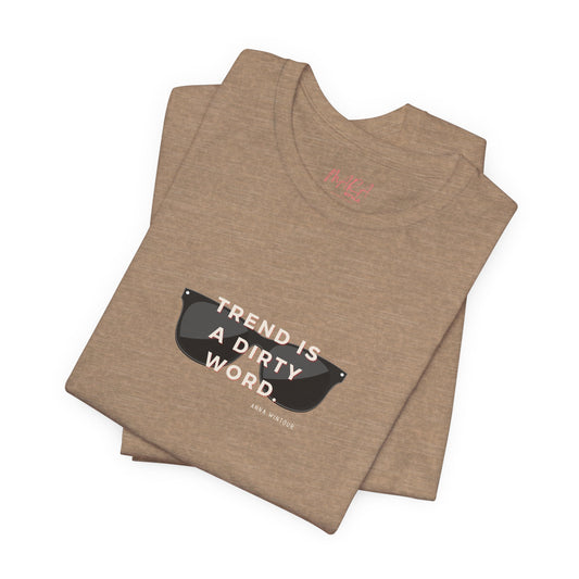 Folded brown t-shirt with sunglasses graphic and Anna Wintour Quote on a white background