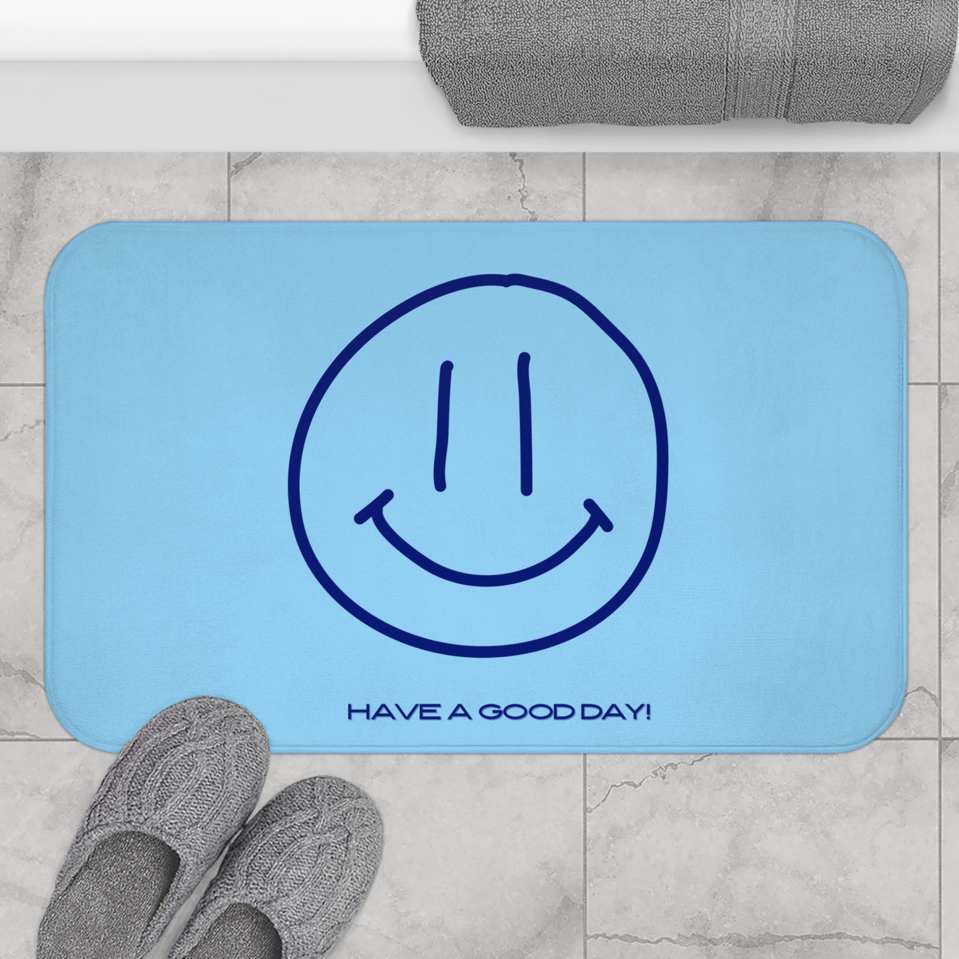 Blue mat with smiley face and 'Have a Good Day!' text on a marble floor.