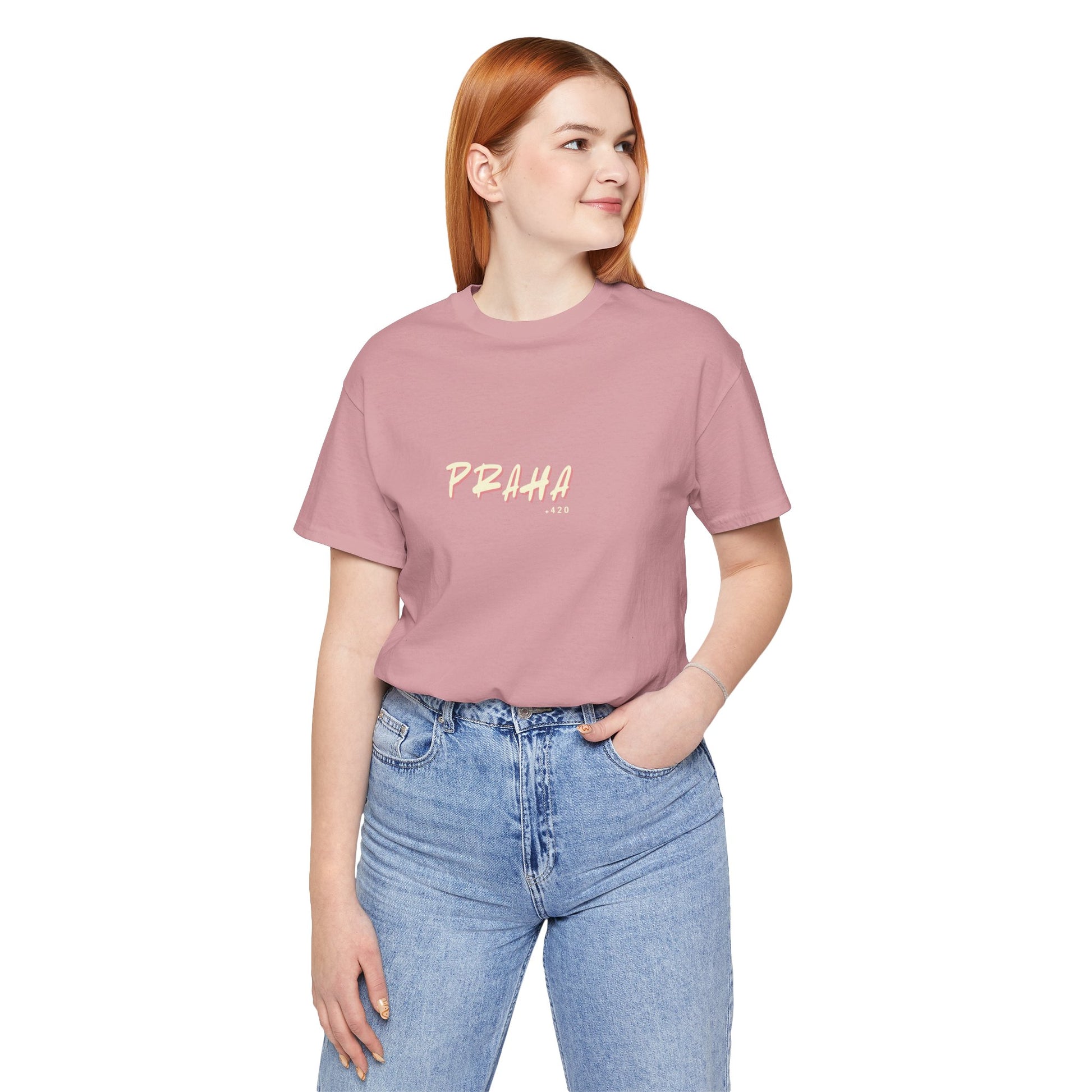 Person wearing a pink t-shirt with 'PRAHA' text and blue jeans on a white background